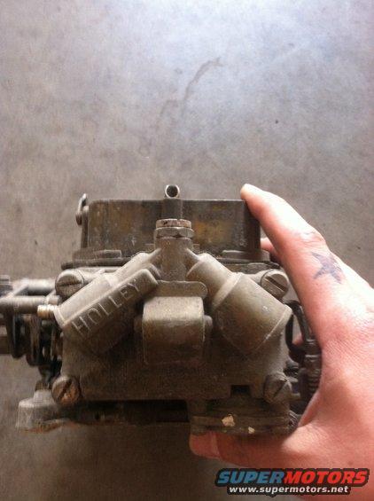 Holley carburetor held by a hand. Text 'HOLLEY' is visible