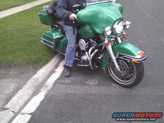 Green motorcycle parked on the side of the road