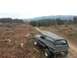 1979 Ford Bronco - A 1979 Ford Bronco navigates a dirt road through a logged area with mountains in the background.