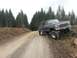 1979 Ford Bronco - This lifted black Ford Bronco is navigating a rough dirt road in a wooded area.