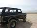 1979 Ford Bronco - This black 1979 Ford Bronco is parked on a sandy beach with the ocean in the background.