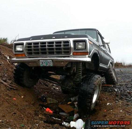 Lifted 1978 Ford Bronco with large tires on muddy terrain