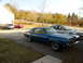 1968 Mercury Cougar - A blue 1968 Mercury Cougar is parked in a driveway with other cars visible in the background.