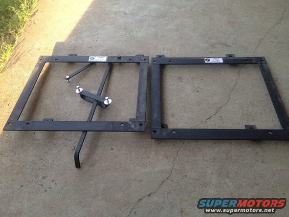 Two metal seat frames on concrete, one with adjustable brackets and bolts