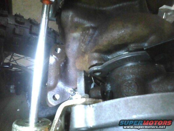 Close-up of a rusty metal part, possibly from a vehicle transmission, with a Supermotors.net watermark