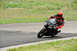 2001 Kawasaki KZ1000-A1 - A motorcycle rider takes a corner on a race track, leaning heavily into the turn.