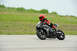 2001 Kawasaki KZ1000-A1 - A rider in full gear navigates a turn on a black sport motorcycle during a track day.