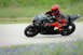 2001 Kawasaki KZ1000-A1 - Rider in full gear on a black sportbike navigates a track.