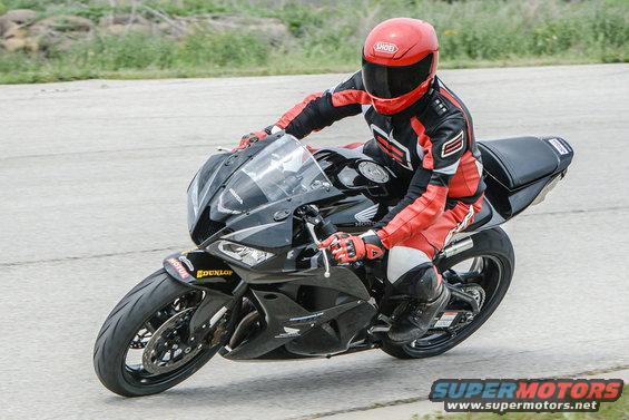Black motorcycle with rider in red and black gear, Dunlop tire