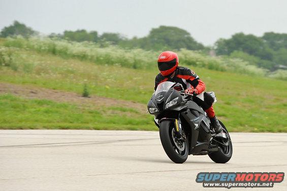 Black motorcycle with rider in red and black gear on a track