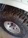 1995 Ford Bronco - A close-up view of a off-road tire mounted on a polished alloy wheel, showing the aggressive tread pattern.