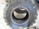 1995 Ford Bronco - A close-up view of a single, aggressive off-road tire, with another tire and wheel partially visible within its opening.
