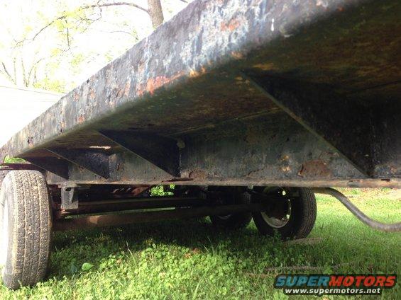 close-up of trailer frame with rust and two wheels visible