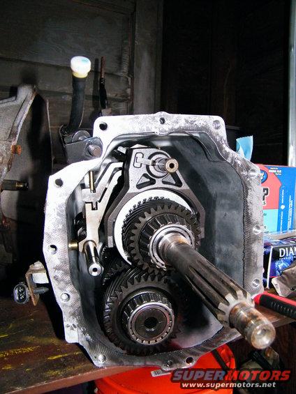 Transmission gears with shafts and shift forks visible inside an open casing