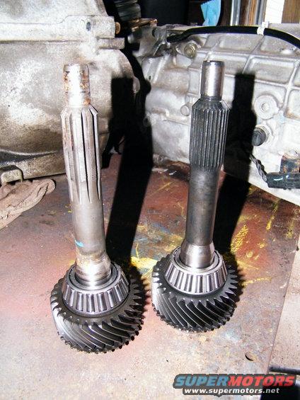 Two transmission input shafts with gears and bearings, one appears worn