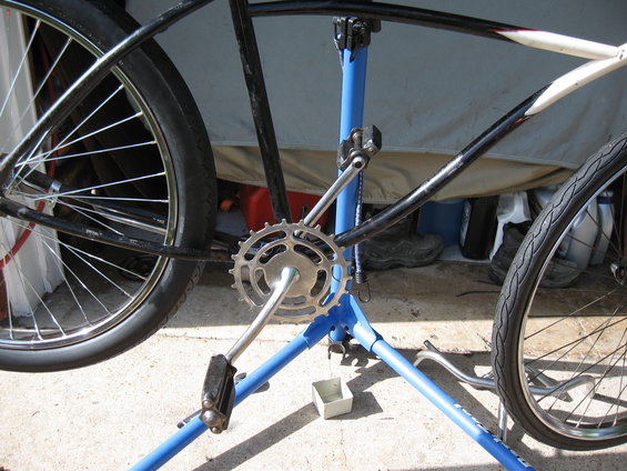 Bike on repair stand, showing crankset, chainring, pedals, and rear wheel