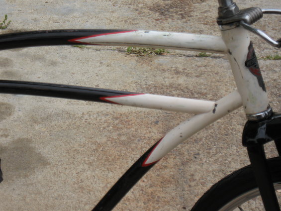 Close-up of a bicycle frame with black and white tubes and red accents