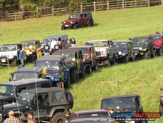 White Ford Bronco with a lifted suspension, parked in a line of Jeeps