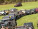 1979 Ford Bronco - A white Ford Bronco is visible in a line of off-road vehicles parked on a grassy hill.