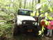 1979 Ford Bronco - A white Jeep CJ is parked on a dirt path in a forest, with two men standing next to it.