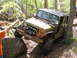 1979 Ford Bronco - Off-road Jeep Wrangler tackling a challenging trail with a spotter guiding the driver.