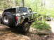 1979 Ford Bronco - A camouflaged Ford Bronco navigates a challenging off-road trail with another vehicle visible in the background.