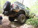 1979 Ford Bronco - This 1979 Ford Bronco is shown off-roading, navigating a large rock with its camouflage paint and external spare tire.