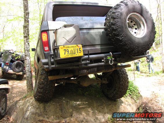 1979 Ford Bronco with camouflage paint, spare tire on rear, and jerrycan mounted