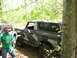 1979 Ford Bronco - A 1979 Ford Bronco with camouflage paint is parked in a wooded area, with a man standing beside it.