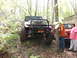 1979 Ford Bronco - Two Jeeps navigate a wooded trail, one in front with a winch and brush guard.