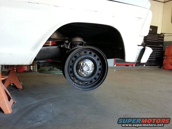 1967 Ford F-100 rear wheel removed, showing suspension and frame. Truck is on jack stands