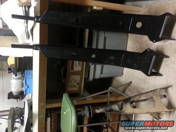 Two black lift kit components, one tan component below