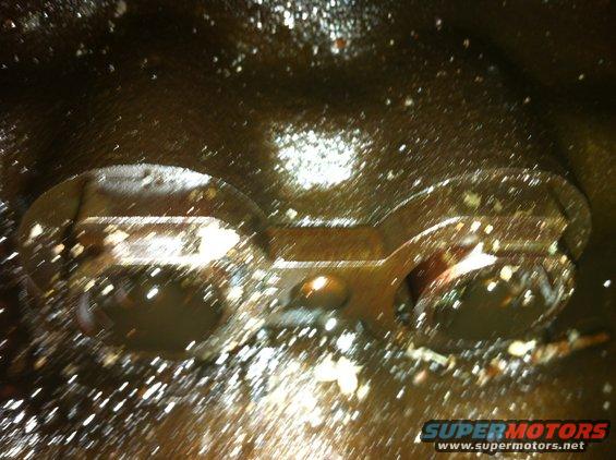 Interior of an engine oil pan with oil and debris