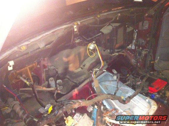 Disassembled vehicle dashboard with exposed wiring and components