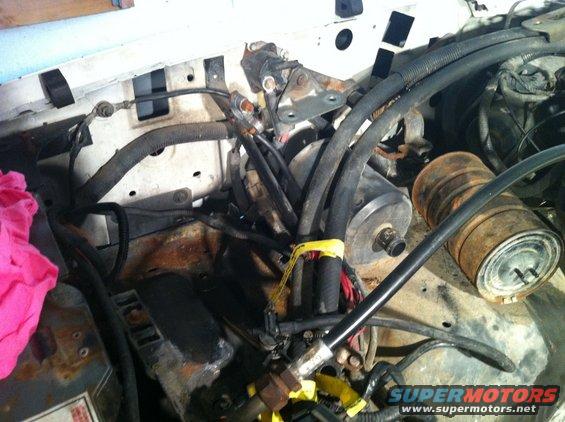 Engine bay with hoses, wires, and rusty components