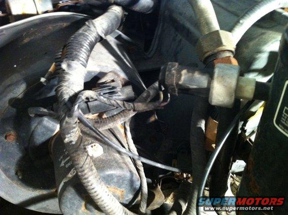 Close-up of engine bay wiring harness and AC lines