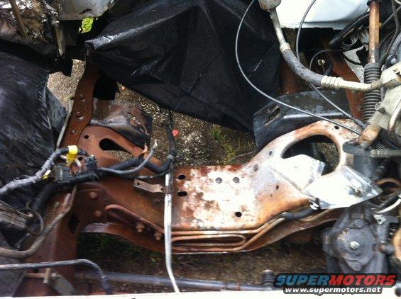 Rusted frame and engine components with black plastic covering