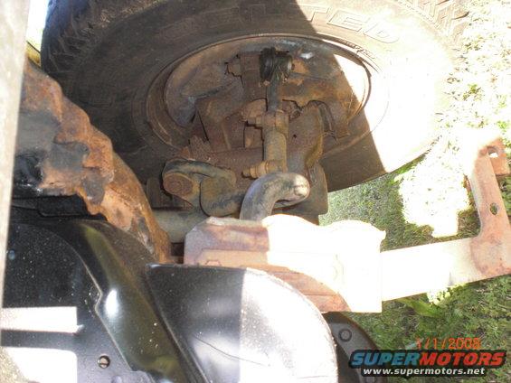 close-up of rusty suspension components and tire