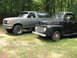 1948 Ford F1 - A black 1948 Ford F1 truck is parked next to a gray SUV in a grassy area with trees in the background.