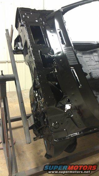 car firewall and dashboard structure, painted black, on a stand