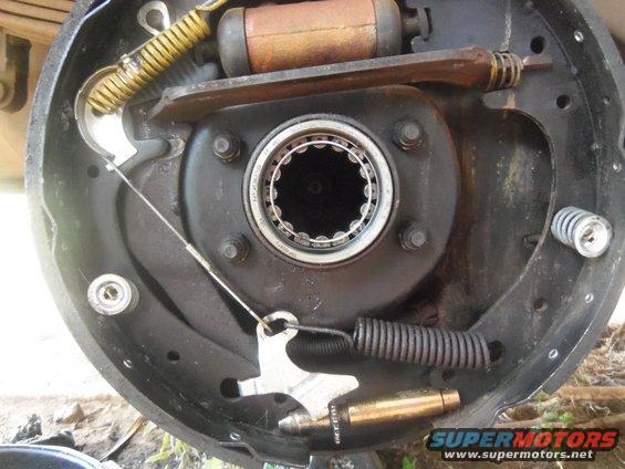 Close-up of a vehicle's brake drum assembly, showing the drum, brake shoes, springs, and wheel cylinder