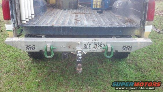 Rear view of a truck bumper with tow hitch and green D-rings. Georgia license plate BGE 7257