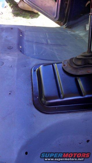 Vehicle interior floor with a black transmission tunnel cover and a black shifter boot