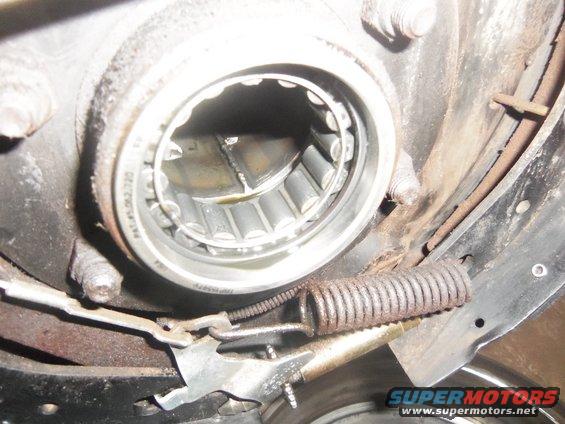 Close-up of a worn wheel bearing assembly with a broken spring