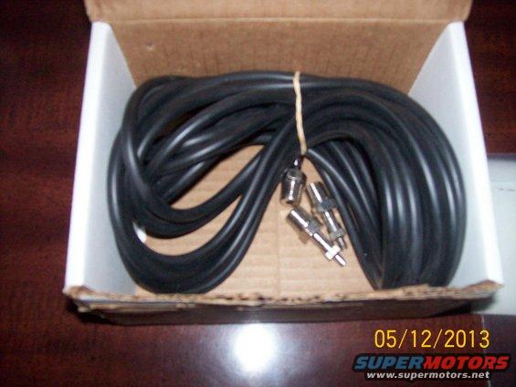 Box containing coiled black audio cables with metal connectors
