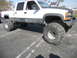 1986 Ford Bronco - This lifted Chevrolet C/K pickup truck features aggressive off-road tires and suspension modifications.