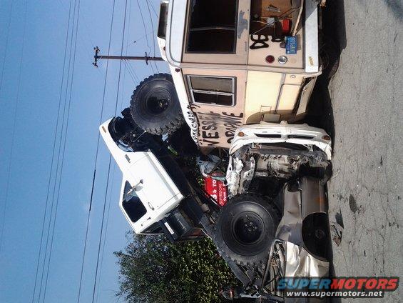 Wrecked white pickup truck and RV on a street