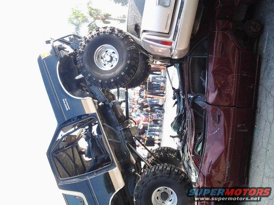Dark blue and tan off-road truck with large tires, tilted