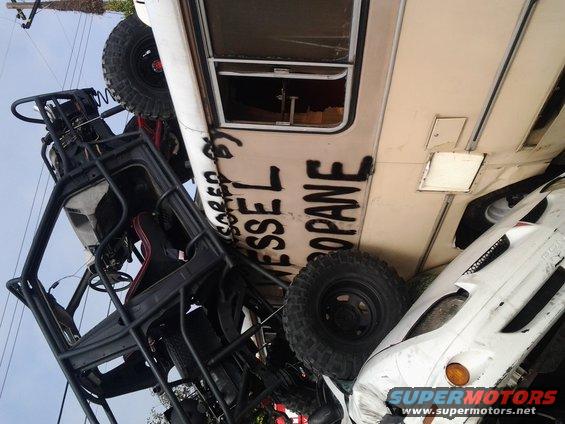Multiple off-road vehicles and a trailer with 'VESSEL PROPANE' spray-painted on its side