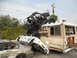 1986 Ford Bronco - A chaotic scene shows an off-road buggy perched on a bus, which is crushing two cars underneath.